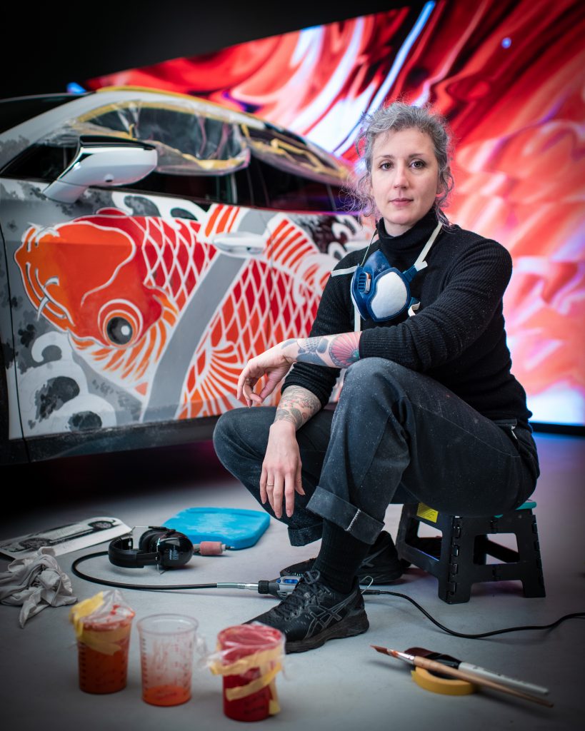 Artist Claudia de Sabe, with the Lexus UX tattooed car